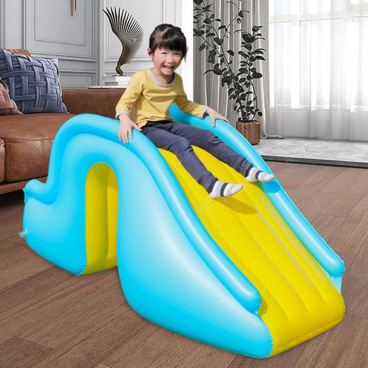 Child sliding down a blue and yellow inflatable slide in a living room.